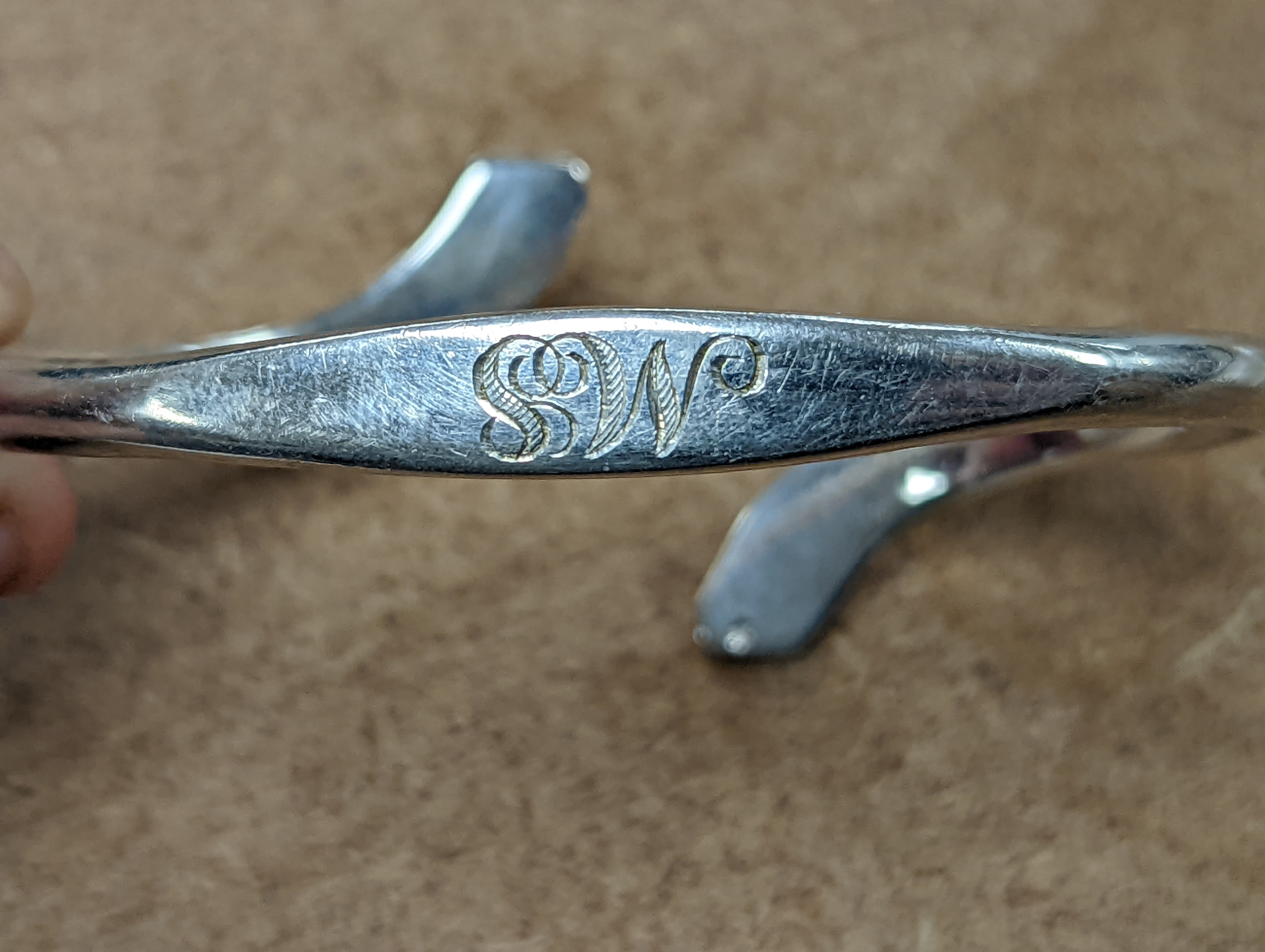 An Art Nouveau style sterling and mother of pearl set pendant necklace, stamped Queensway, 62cm and a white metal bangle.